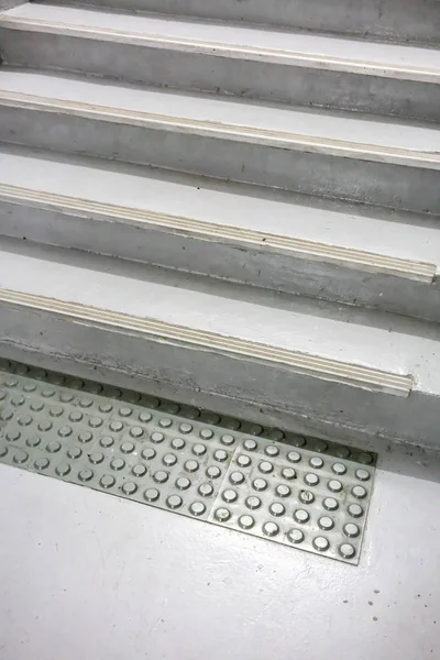 Alfombra antideslizante gris vieja en piso a escalera pintada blanca cerrada — Foto de Stock