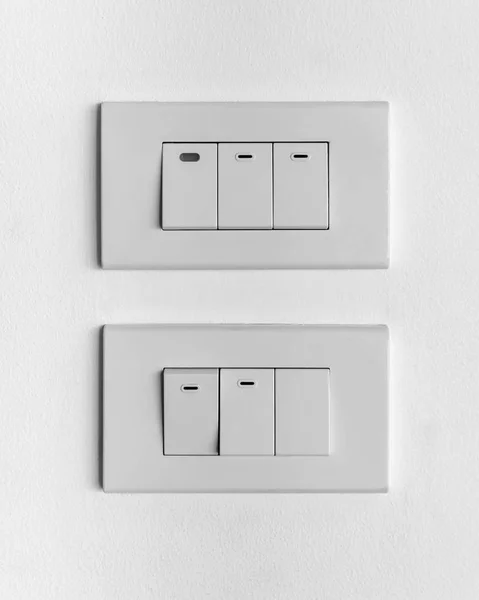 Dois conjuntos brancos de interruptores de iluminação tripla na parede de concreto — Fotografia de Stock