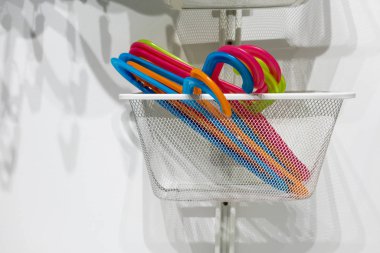 Beyaz metal sepet içinde renkli plastik askı 
