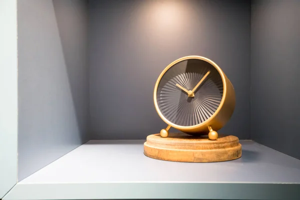 Horloge moderne en or et noir sur étagère grise pour la décoration — Photo