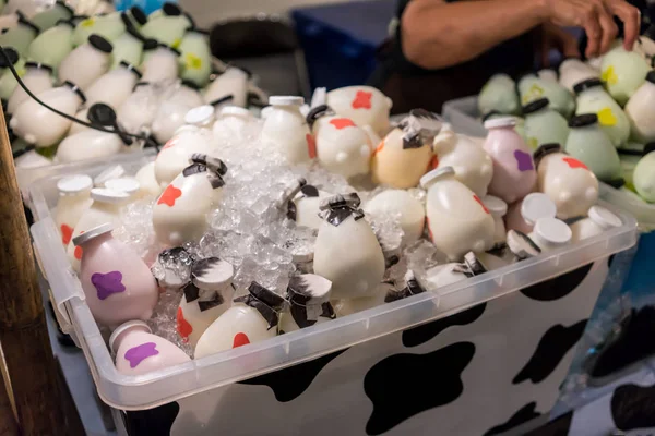 Красочные пластиковые бутылки молока кладут в коробку со льдом — стоковое фото