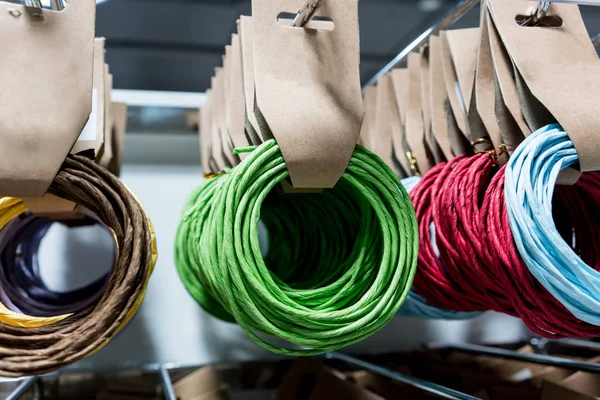 Filas de cuerda de papel multicolor colgando en rack para mayorista stor — Foto de Stock