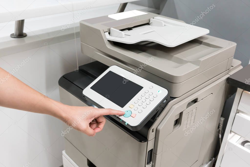 Woman's hands pressing button on copy machine