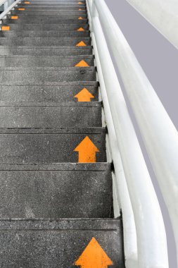 Yellow arrow on public concrete ladders clipart