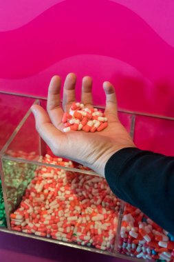 Pembe ve beyaz kapsül ilaç grubu tutan kadın el
