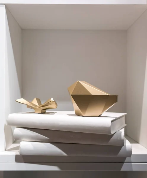 Peso de papel abstrato dourado colocando em uma pilha de livro de capa branca — Fotografia de Stock