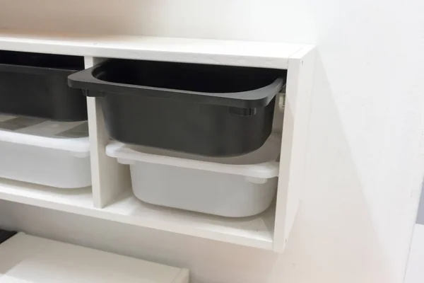 Cajón de almacenamiento de plástico blanco y negro en gabinete blanco para habitación — Foto de Stock