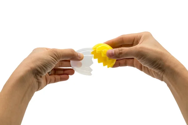Mani che rompono un uovo giallo artificiale isolato su bianco — Foto Stock