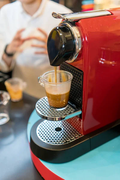 Een rood modern uitziende koffie espressomachine is het maken van een kopje koffie — Stockfoto