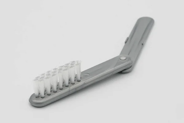 Cepillo de plástico plegable pequeño en color gris aislado en blanco —  Fotos de Stock