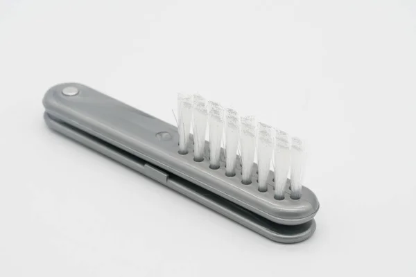 Pequena escova de plástico dobrável na cor cinza isolada no branco — Fotografia de Stock