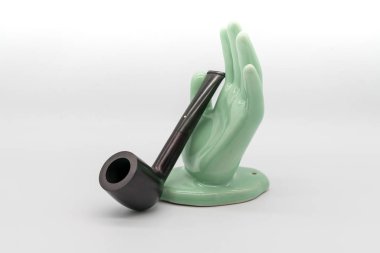 Yeşil seramik sol el ve vintage boru üzerinde beyaz izole 
