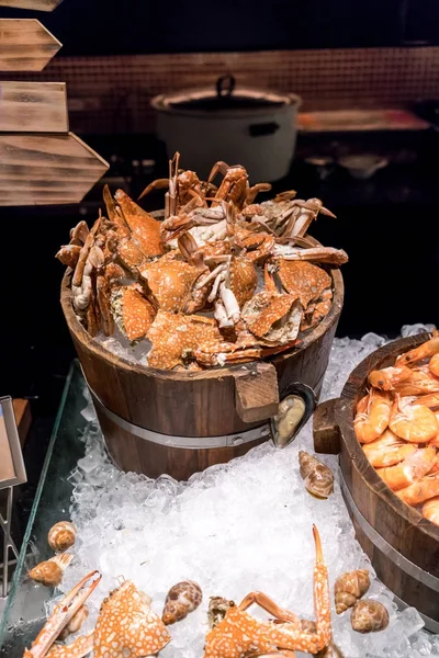 Caranguejos cozidos no vapor e camarões no gelo em baldes de madeira com direção — Fotografia de Stock