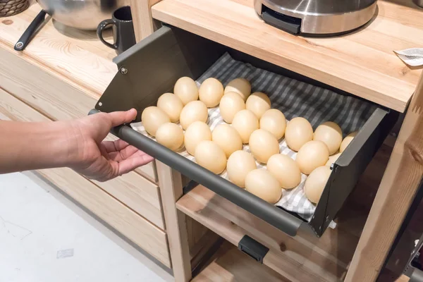 Mano tirando del cajón de la cocina de metal lleno de huevos falsos para disp — Foto de Stock