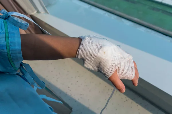 Girl's hand with an elastic bandage  with the tube of normal sal