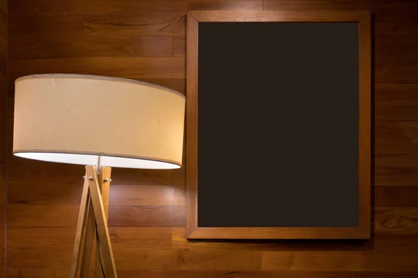 Черная доска с деревянной рамой и современной круглой лампой — стоковое фото