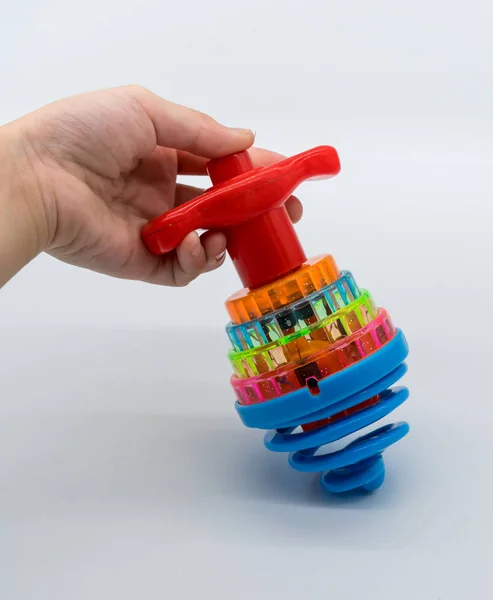 Mão segurando colorido LED girando Top Toy isolado no branco — Fotografia de Stock