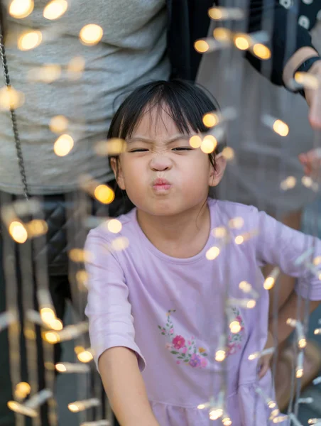 Asain menina com rosto engraçado e Chrismas lightihng decoração — Fotografia de Stock