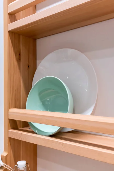 Зелена керамічна чаша та біла порцелянова тарілка на дерев'яній стійці агаї — стокове фото