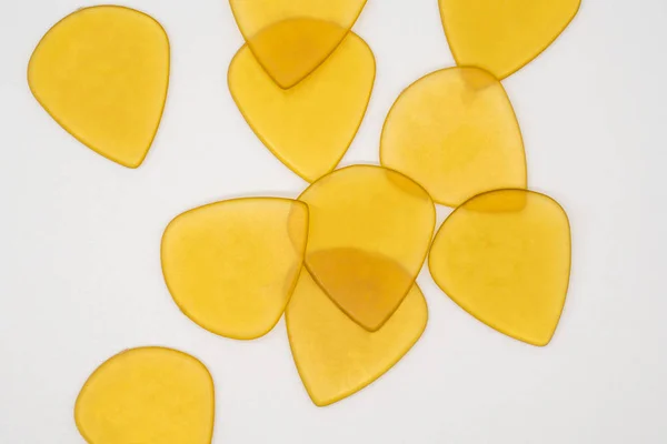 Transparente gelbe Plastikgitarren-Plektren isoliert auf weiß — Stockfoto