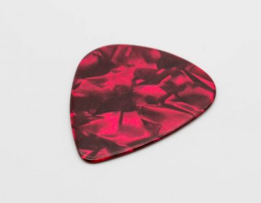 Beyaz arka plan üzerinde izole koyu kırmızı plastik gitar mızrap. 