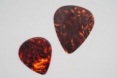 İki farklı boyutlarda üzerinde izole kahverengi plastik gitar mızrap