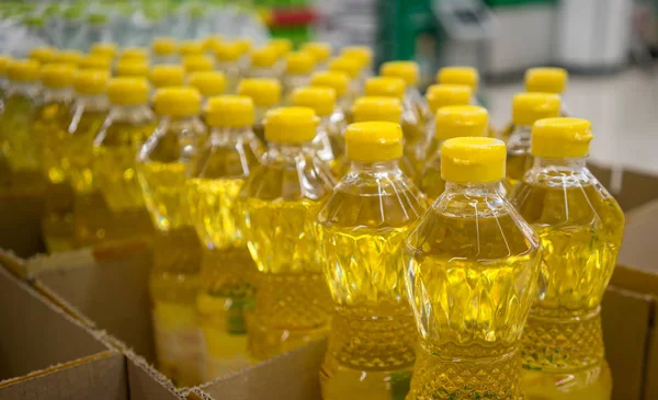 Cooking oil bottles with yellow caps on shelf in supermarket. — Stock Photo, Image