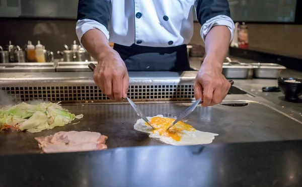 Mão do Chef cozinhando ovo na panela quente na frente dos clientes . — Fotografia de Stock