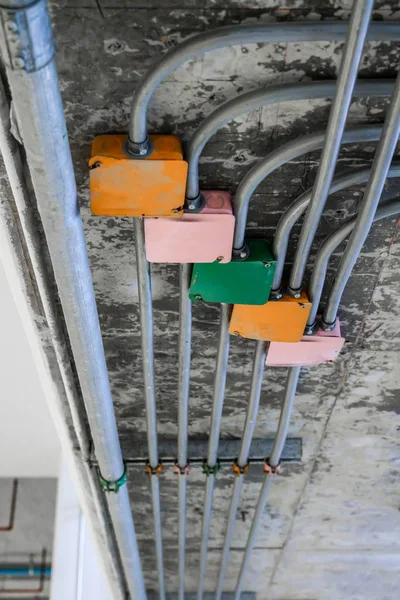 Fios elétricos em tubos de alumínio que atravessam o cei de concreto — Fotografia de Stock