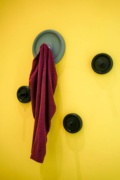 Red baby pants hanging on modern grey wall hook mounted 