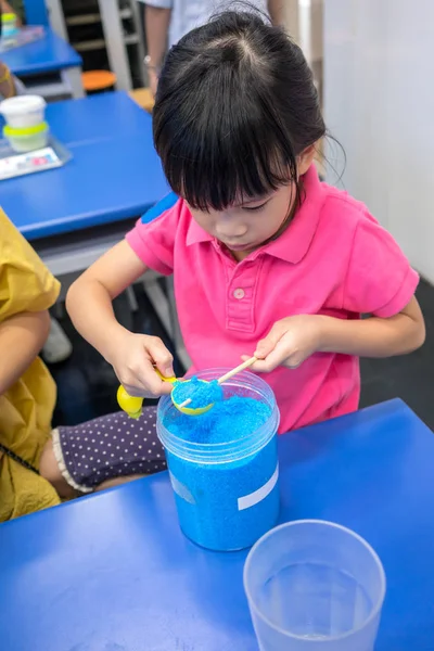 Ребенок с помощью палочки для выравнивания синего химиката в измерении sp — стоковое фото