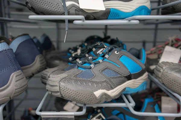 Sapatos esportivos em prateleiras de metal na loja — Fotografia de Stock