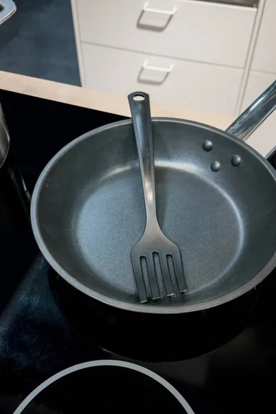 Шпатель у сковороді з тефлоновим покриттям на електроплиті — стокове фото