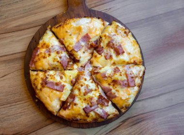 pastırma jambon ve pieapple ahşap masa üzerinde pizza
