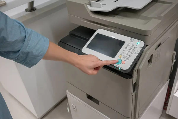 Las manos de la mujer presionando el botón en la máquina de copia en la oficina — Foto de Stock