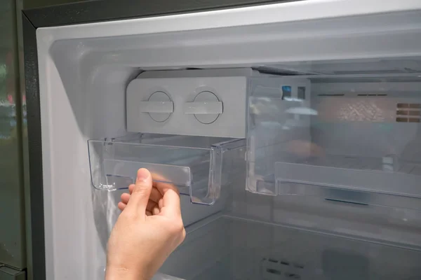 Mulher mão aberta recipiente de gelo de plástico transparente na geladeira . — Fotografia de Stock