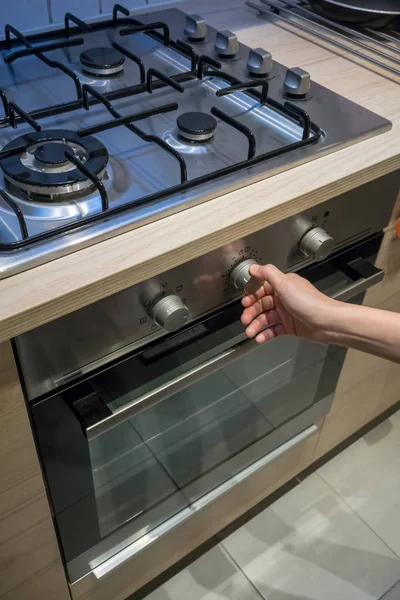 Manos de mujer botón de ajuste de temperatura en el horno — Foto de Stock