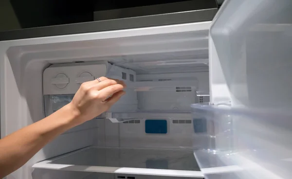 Mujer mano abierta recipiente de hielo de plástico transparente en el refrigerador . — Foto de Stock
