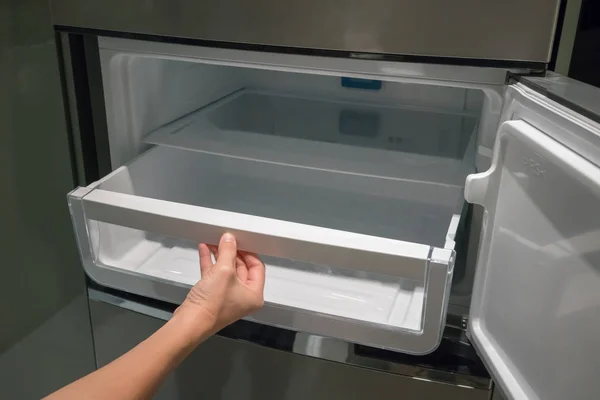 Cajón contenedor blanco de plástico abierto a mano de mujer en nevera . — Foto de Stock