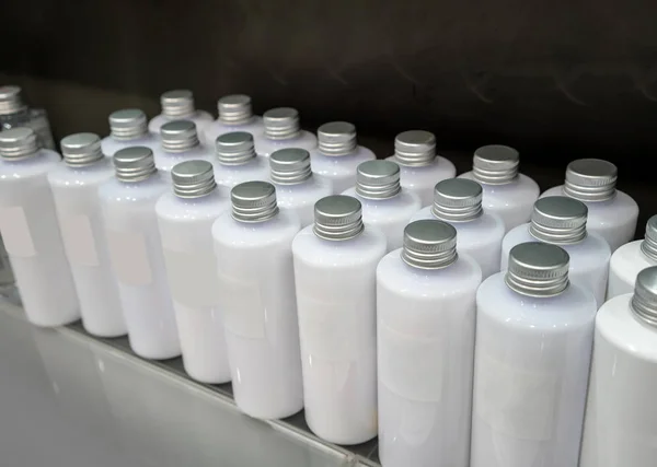 Shiny silver caps of white plastic bottles in rows for pattern b — Stock Photo, Image