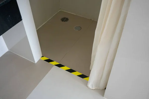 Βήμα προειδοποίηση μέσα σε τουαλέτα ή τουαλέτα. κίτρινο-μαύρο μοτίβο. — Φωτογραφία Αρχείου