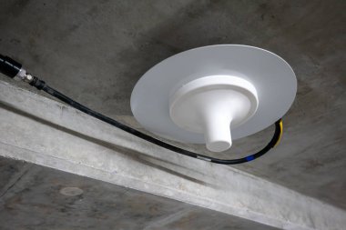 Neon lig altında beton tavan boyunca çalışan elektrik telleri