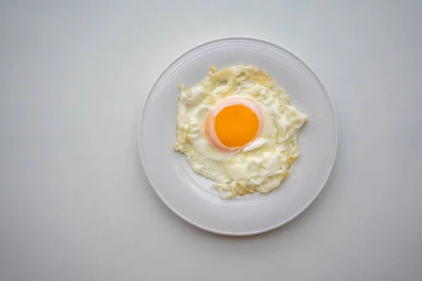 Τηγανητό αυγό στο λευκό κεραμικό πιάτο ή το πιάτο που απομονώνονται σε λευκό backg — Φωτογραφία Αρχείου