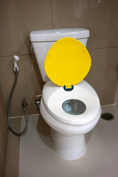 Moderne toilet met gele en witte Kinder-autostoeltje — Stockfoto