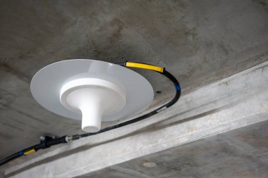 Neon lig altında beton tavan boyunca çalışan elektrik telleri