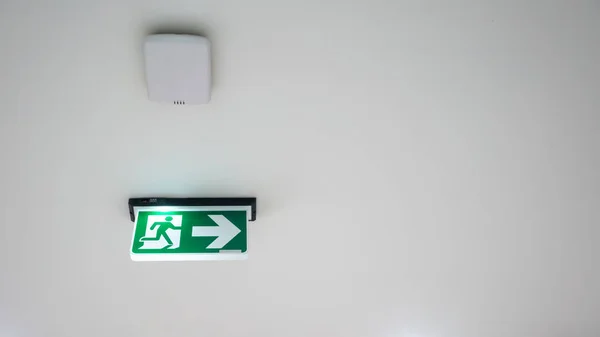 Znak zielony wyjście awaryjne. Kierunek na drogę ucieczki na białym — Zdjęcie stockowe