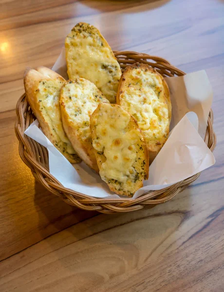 Pan de ajo y hierba con queso en la canasta — Foto de Stock