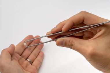 Süt dişleri ile gümüş metal cımbız izole o toplama el