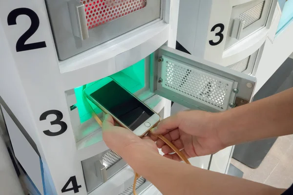 Mano sosteniendo el teléfono inteligente blanco y enchufando el cable de la carga —  Fotos de Stock