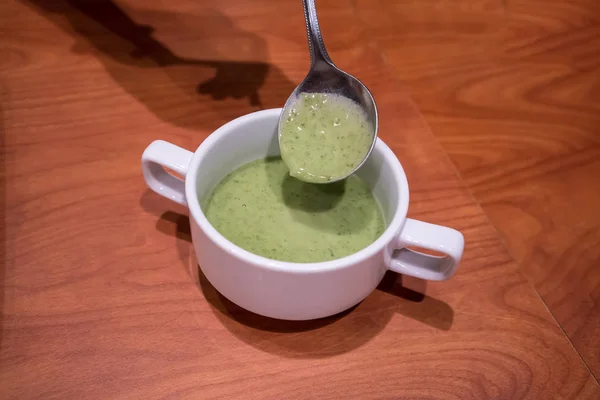 Encerrado sopa de espinacas verdes frescas en cuchara sobre una pequeña b blanca — Foto de Stock